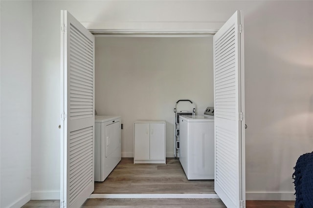 clothes washing area featuring light wood-type flooring and independent washer and dryer