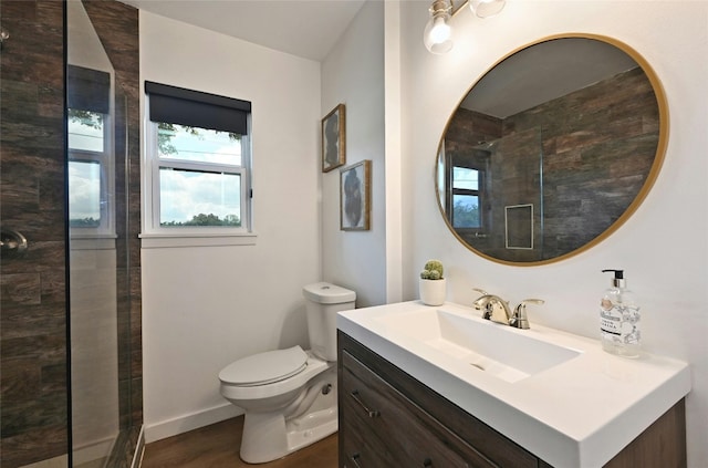 bathroom featuring wood-type flooring, vanity, toilet, and a tile shower