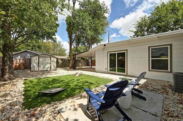 view of yard with central air condition unit, a storage unit, and a patio