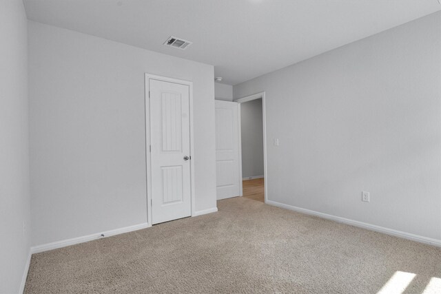 unfurnished bedroom featuring light carpet