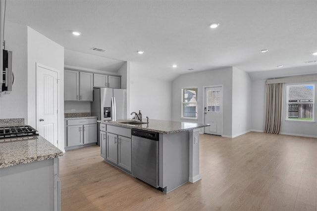 kitchen featuring gray cabinetry, stainless steel appliances, a kitchen island with sink, and sink