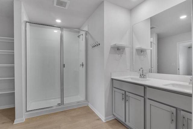 bathroom with an enclosed shower, vanity, and hardwood / wood-style floors