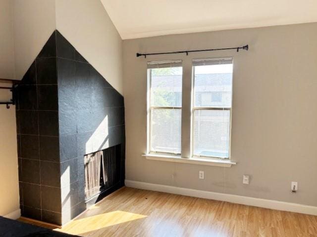 5608 Cougar Dr Unit 219, Austin, TX 78745 - unfurnished living room featuring wood finished floors, baseboards, and lofted ceiling