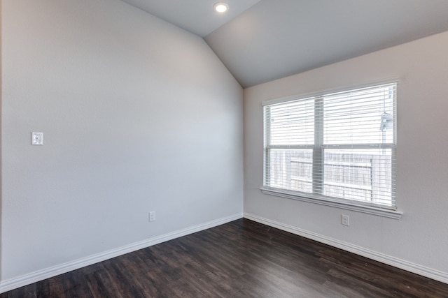 empty room with vaulted ceiling and dark hardwood / wood-style floors