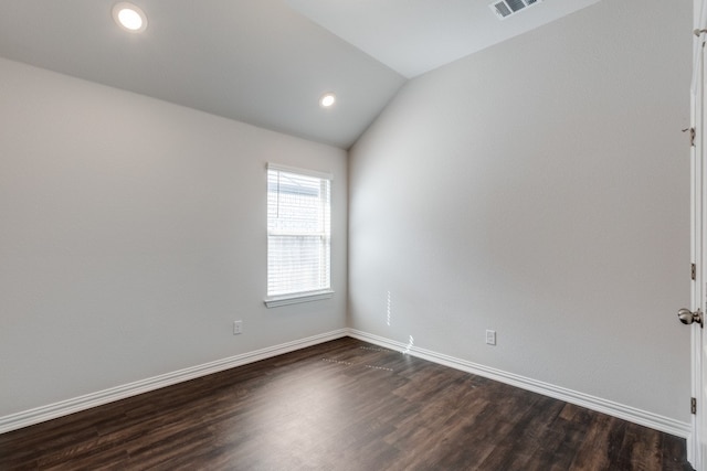 spare room with lofted ceiling and dark hardwood / wood-style floors