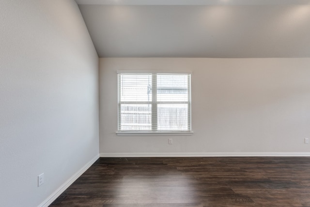 unfurnished room featuring vaulted ceiling and dark wood-type flooring