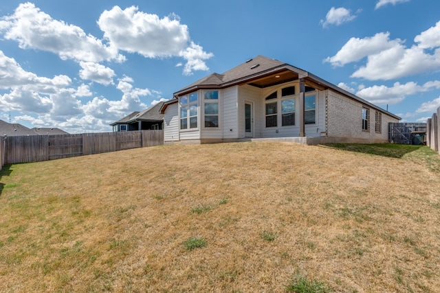 rear view of property with a lawn