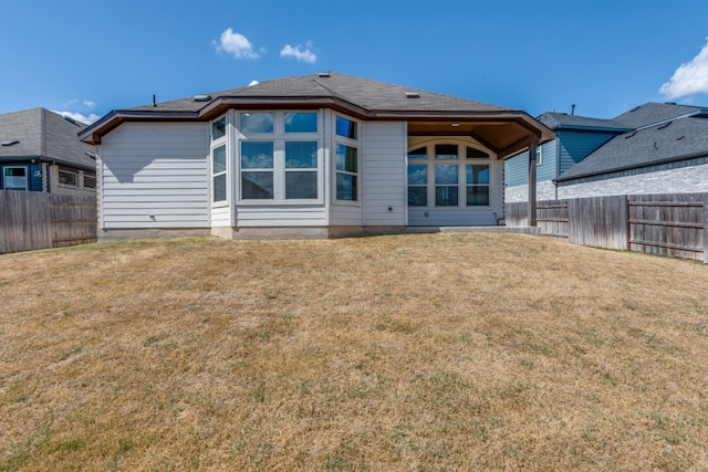 rear view of property featuring a lawn