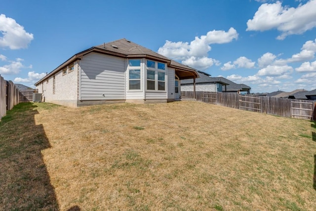 509 Oleander Loop, Buda, TX 78610 - back of property with a lawn, central AC, and a fenced backyard
