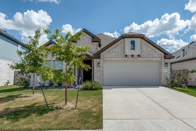 509 Oleander Loop, Buda, TX 78610 - french country style house with a front lawn, concrete driveway, and brick siding
