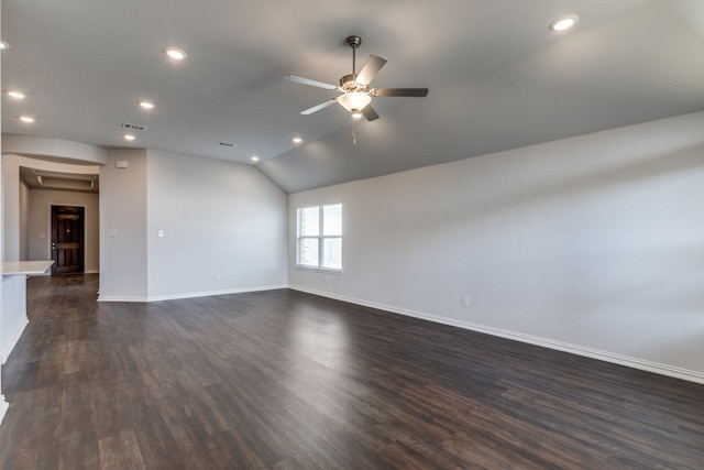 empty room with ceiling fan, vaulted ceiling, and dark hardwood / wood-style flooring