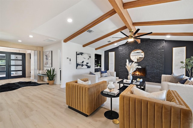 living room featuring french doors, a fireplace, lofted ceiling with beams, ceiling fan, and light hardwood / wood-style flooring