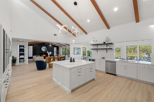 kitchen with white cabinets, a kitchen island, hanging light fixtures, high vaulted ceiling, and stainless steel dishwasher