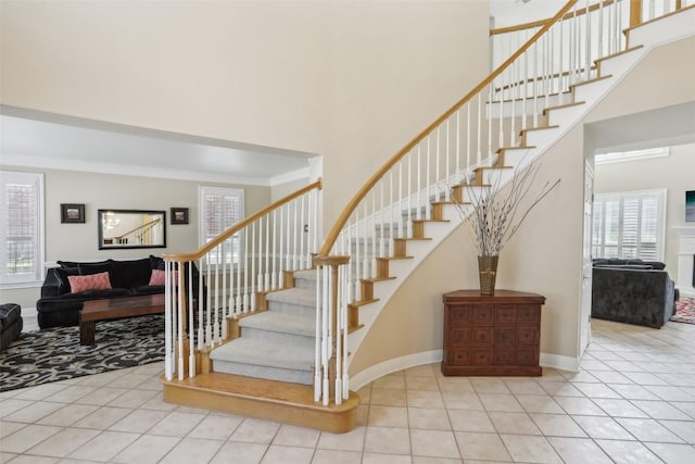 stairway with tile patterned flooring and a high ceiling