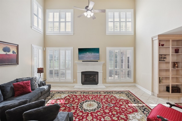 tiled living room with ceiling fan and a towering ceiling