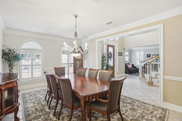 dining area featuring crown molding, light tile patterned flooring, and a chandelier