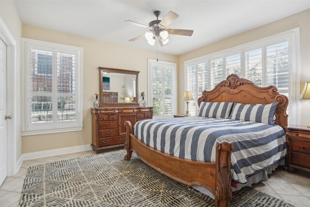 bedroom with multiple windows, ceiling fan, and light tile patterned floors