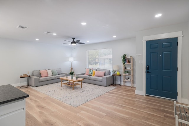 living room with light wood-type flooring and ceiling fan