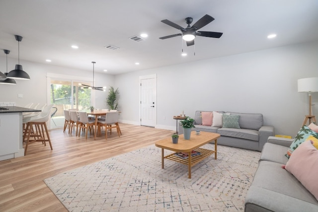 living room featuring ceiling fan and light hardwood / wood-style floors