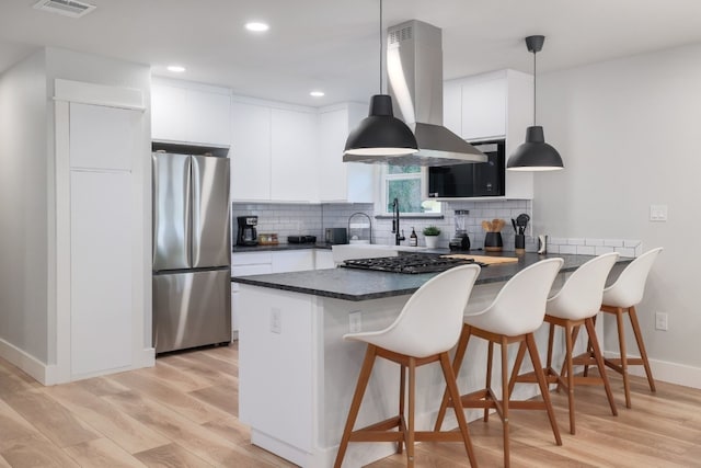 kitchen with white cabinets, stainless steel appliances, and hanging light fixtures