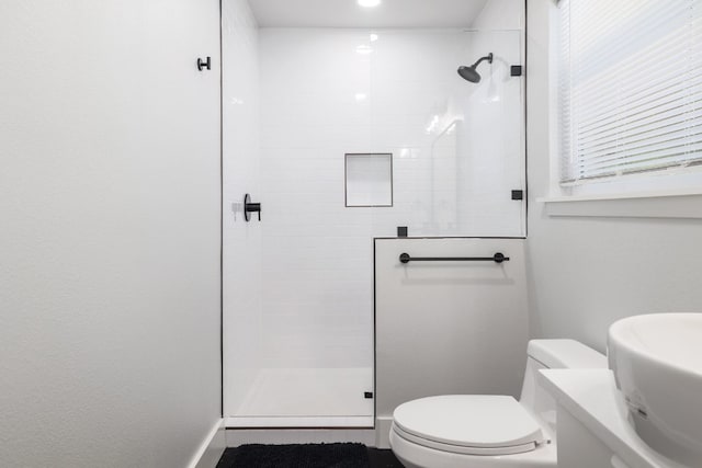 bathroom with tiled shower and toilet