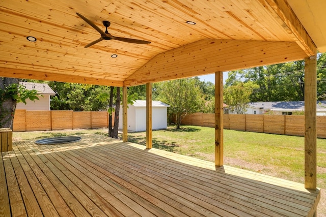 deck featuring a lawn, a storage shed, and ceiling fan