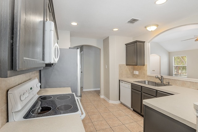 kitchen featuring dark brown cabinets, white appliances, ceiling fan, sink, and light tile patterned floors