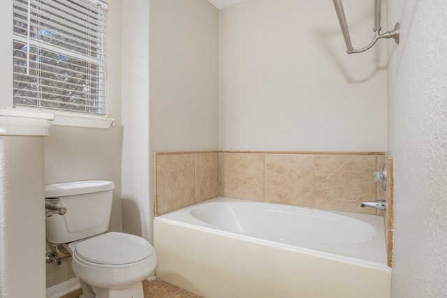 bathroom with tile patterned floors, toilet, and a bath