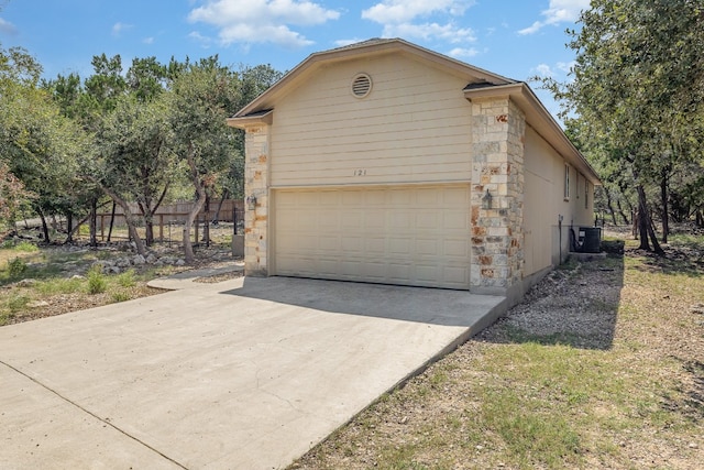 view of side of home featuring a garage and central AC unit