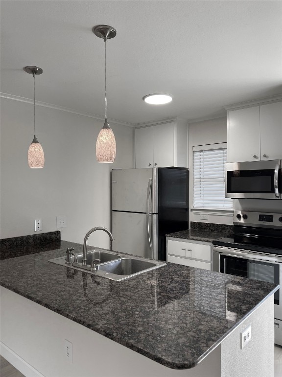 kitchen with hanging light fixtures, white cabinetry, sink, and stainless steel appliances