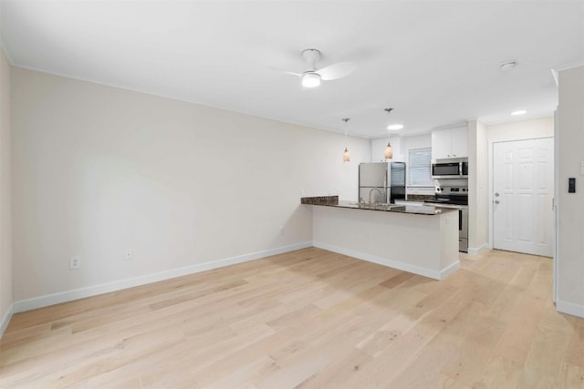 kitchen with hanging light fixtures, white cabinetry, kitchen peninsula, stainless steel appliances, and ceiling fan