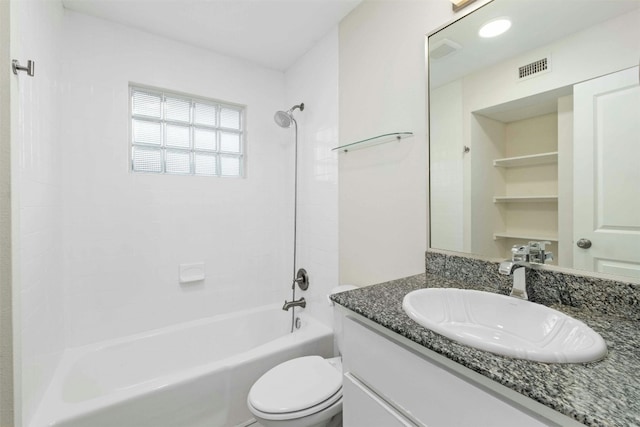 full bathroom with tiled shower / bath, vanity, and toilet