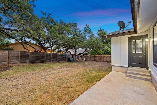 6700 Colina Ln, Austin, TX 78759 - yard at dusk featuring entry steps, a fenced backyard, and a patio area