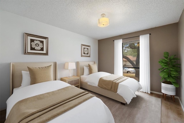 6700 Colina Ln, Austin, TX 78759 - bedroom with light wood finished floors and a textured ceiling