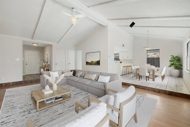 living room featuring a textured ceiling, lofted ceiling with beams, and hardwood / wood-style floors