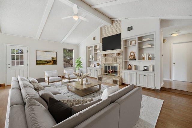 living room with a brick fireplace, plenty of natural light, hardwood / wood-style floors, and ceiling fan