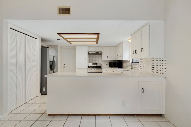 kitchen featuring appliances with stainless steel finishes, kitchen peninsula, sink, and white cabinets