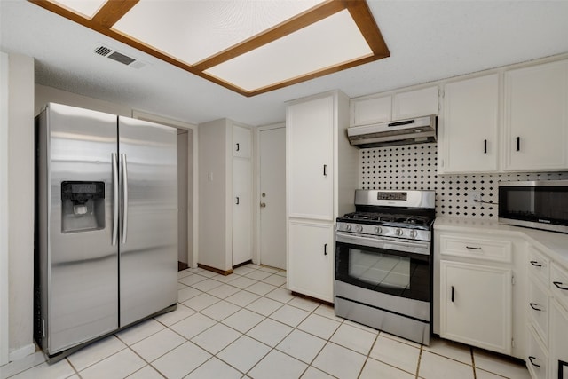 kitchen with decorative backsplash, stainless steel appliances, white cabinets, and light tile patterned flooring