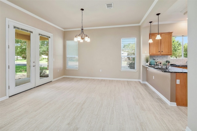 kitchen featuring ornamental molding, backsplash, hanging light fixtures, and a notable chandelier