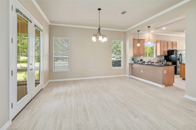 kitchen with a notable chandelier, kitchen peninsula, decorative light fixtures, decorative backsplash, and ornamental molding