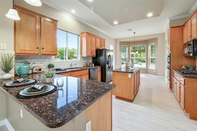 kitchen with dark stone countertops, a center island, and decorative light fixtures