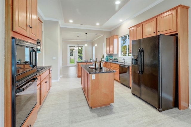 kitchen featuring black appliances, hanging light fixtures, dark stone countertops, a notable chandelier, and a kitchen island