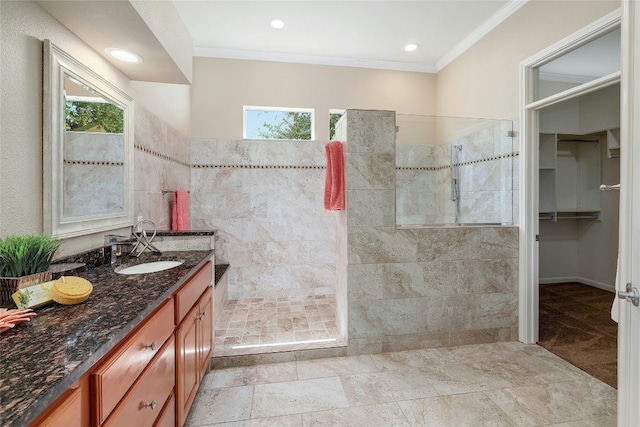 bathroom featuring tiled shower, plenty of natural light, vanity, and ornamental molding