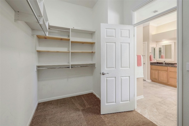 walk in closet featuring light colored carpet