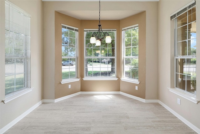 unfurnished dining area featuring an inviting chandelier