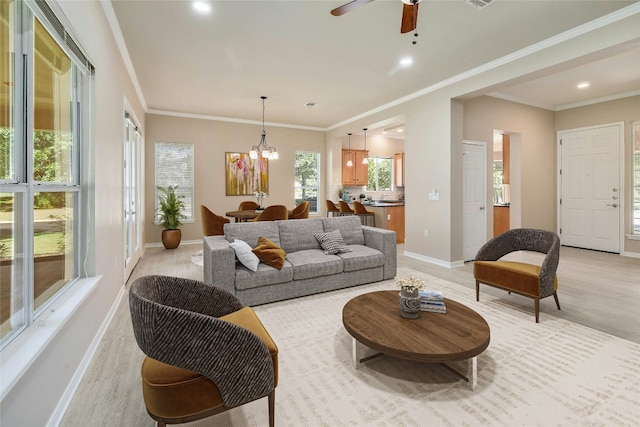 living room featuring light wood-type flooring, ceiling fan with notable chandelier, and ornamental molding