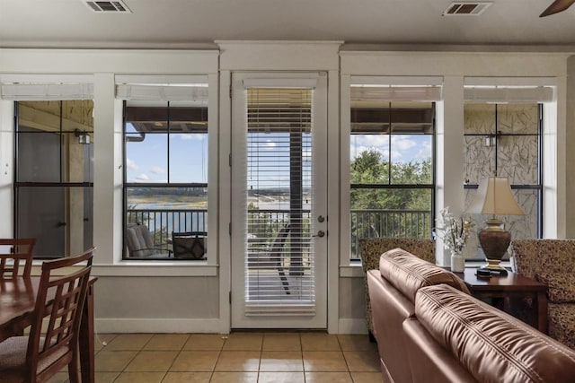 doorway to outside with light tile patterned flooring, ceiling fan, and a wealth of natural light