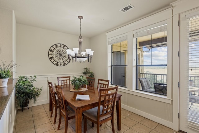 tiled dining area with an inviting chandelier