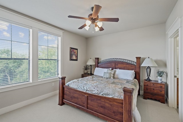 bedroom featuring multiple windows, light carpet, and ceiling fan