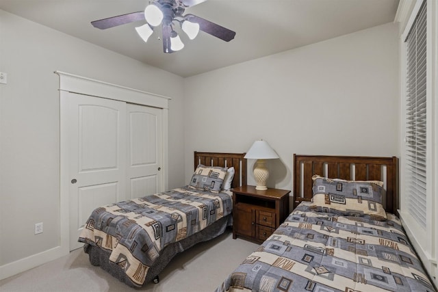 carpeted bedroom featuring ceiling fan and a closet